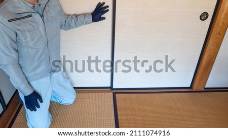A worker who inspects the sliding doors. "Japanese fusuma and tatami" Royalty-Free Stock Photo #2111074916