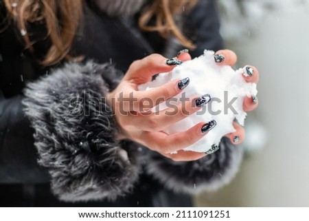 Girl's hands holding snow, making snowball