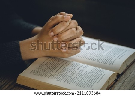 Christian life crisis prayer to god. Women Pray for god blessing to wishing have a better life. Hands praying to god with the bible. believe in goodness. Holding hands in prayer on a wooden table.