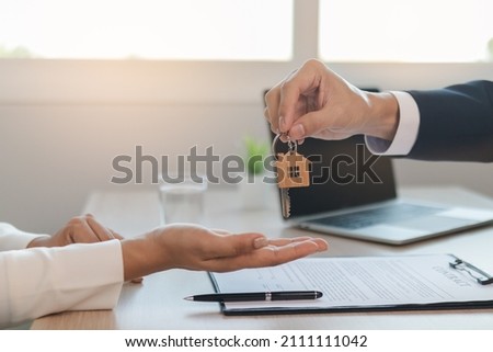 Deal done landlord, realtor man hold key offer new renter, tenant or client after banker approved, signed purchase agreement. Finance, financial of property, estate mortgage or apartment, home loan. Royalty-Free Stock Photo #2111111042