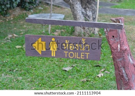 Sign wood of go to toilet with Thai language.
