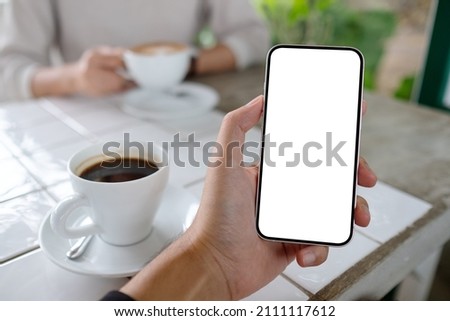 Mockup image of a man holding mobile phone with blank white screen with a woman in background