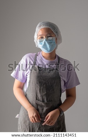 Young woman chef with blue mask in studio shot