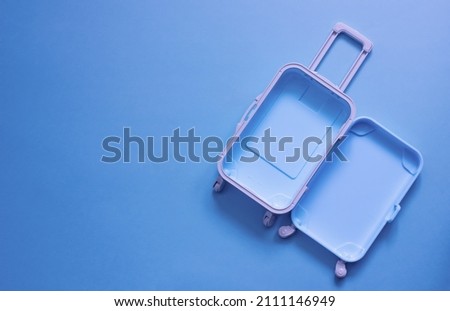 Fully opened blue suitcase, on a blue background, top view. Vacation, travel concept. copy space Royalty-Free Stock Photo #2111146949