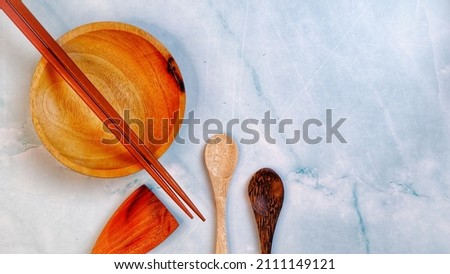 Wooden kitchenware that gives a classic and minimalist impression. Food and drink concept. Food Photography. Flat Lay, Close up Wooden Bowl and chopsticks on the table.