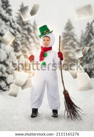 a child in a snowman costume holding a lantern in his hands against the background of a green snowy forest. Picture for advertising or banner. Fabulous photo shoot