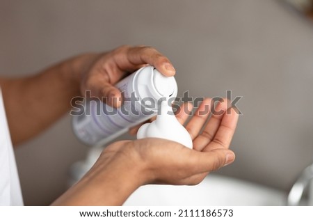 Unrecognizable man applying shave foam on hand, standing in bathroom and preparing for shaving, closeup. Guy making morning beauty routine at home Royalty-Free Stock Photo #2111186573