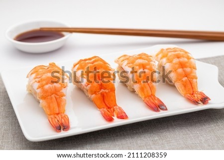 Ebi nigiri sushi or shrimp nigirizushi, molds of seasoned cooked Japanese rice, Kome, with toppings of fresh cooked shrimp prawn. Sushi is a kind of Japanese food well-know all over the world.  Royalty-Free Stock Photo #2111208359