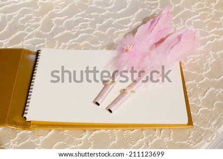 Photo of a wedding register and feather pen. Wedding guestbook.