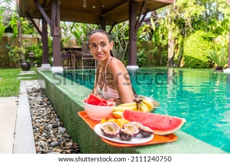 Attractive woman in a beautiful villa with swimming pool in a tropical climate location - Happy people on a summer vacation, influencers enjoying a luxury resort