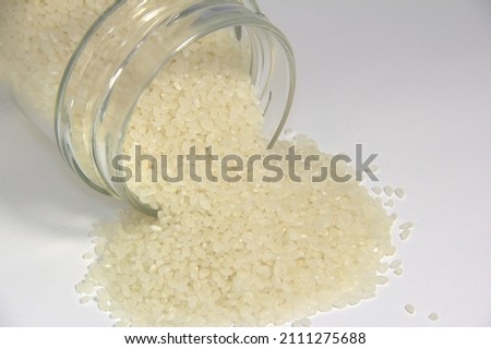 Sprinkled white rice from a transparent jar.
