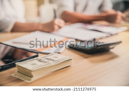 Man offering batch of hundred dollar bills. Hands close up. Venality, bribe, corruption concept. Hand giving money - United States Dollars (or USD). man counting money at the table.
