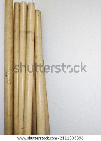 Wooden sticks on the isolated white wall background. Stationary concept. Portrait photo. Negative space
