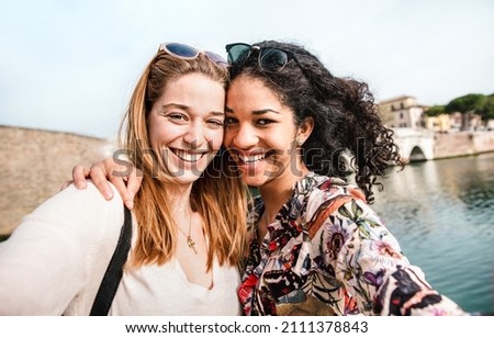 Multicultural female best friends taking selfie having fun together - Friendship concept with happy girls at summer vacation - Milenial life style concept on young beautiful women - Bright warm filter Royalty-Free Stock Photo #2111378843