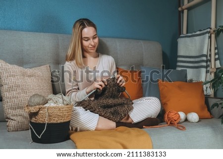 Girl knitting at home.Handmade zero waste,upcycling,New small business employment opportunity concept.Hobby knitting and needlework for mental health.Knitted background
