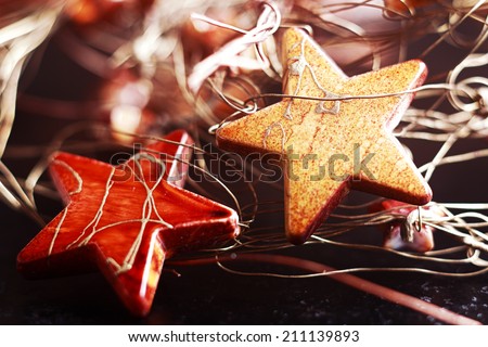 Decorating for Christmas festivities with a jumbled background of two colourful stars with string lying waiting to be hung on the tree