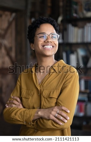 Happy excited young Black business woman professional head shot portrait. Female African American business leader looking away with toothy smile thoughtful face, dreaming, thinking of future career