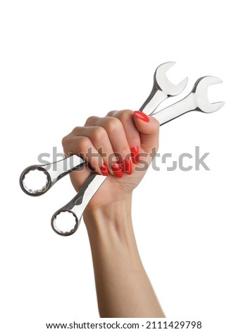 Woman's hand with a red manicure and a wrench on an isolated white background. Royalty-Free Stock Photo #2111429798