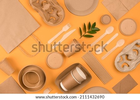 Eco-friendly tableware - kraft paper food packaging on yellow or orange background. Street food paper packaging, recyclable paperware, zero waste packaging concept. Flat lay, mockup image Royalty-Free Stock Photo #2111432690