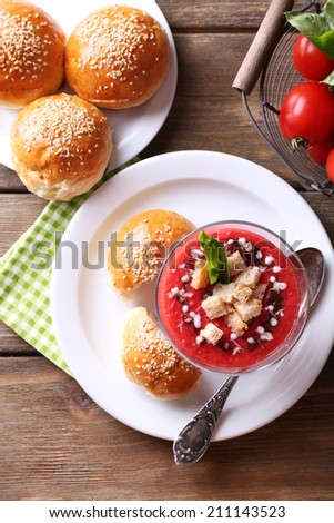 Gazpacho soup in glass bowl, on color wooden background