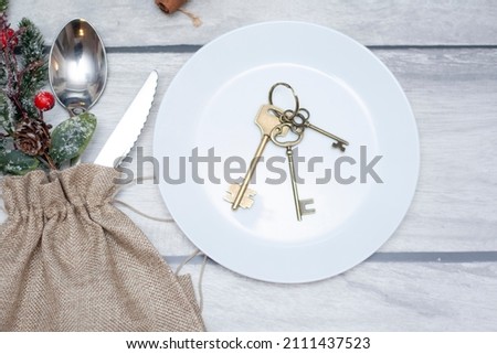 Christmas gift house with keys on wooden background