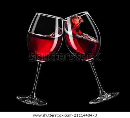 two glasses of red wine toasting isolated on black background Royalty-Free Stock Photo #2111448470
