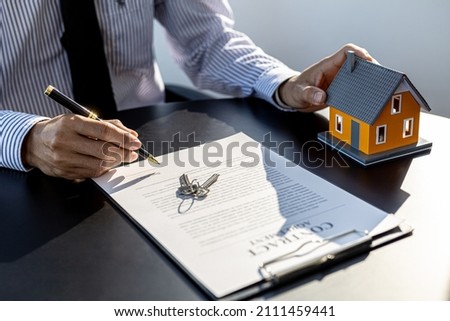 The salesperson of the housing estate in the project is preparing and verifying the contract of sale for the customer who will enter the contract. Concept of selling housing estates and real estate.