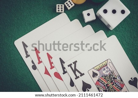 Playing cards and board game figures arranged on a poker table in a casino. Poker card game, winning combination