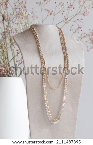 Close up picture of gold and silver plated necklaces with natural lighting on a blurry background
