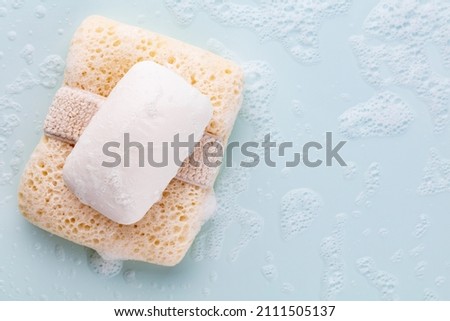 Soap bar and foam on pastel background Royalty-Free Stock Photo #2111505137