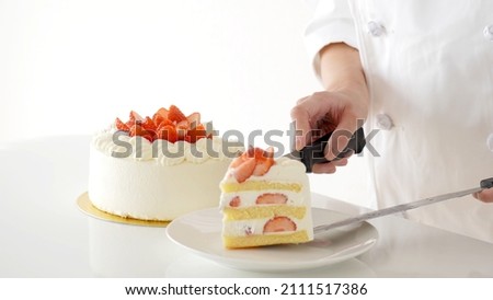 pastry chef serving strawberry cake isolated on white background. Royalty-Free Stock Photo #2111517386