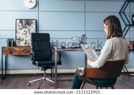 Woman came to the office with the documents and is preparing to report to the manager. Royalty-Free Stock Photo #2111522903