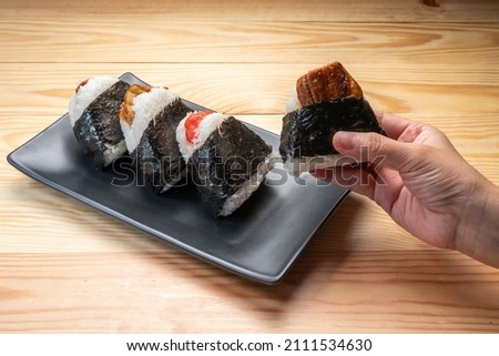 Onigiri or Japanese seaweed rice triangles shaped Stuffed with grilled eel, scallop, plum and fish roe, Japanese Rice Balls  famous food. Royalty-Free Stock Photo #2111534630