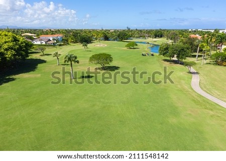 Golf club field with cart and playing golfers. Aerial view from drone