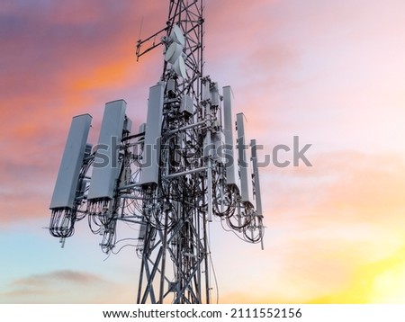Cell tower with 5G antennas at sunset Royalty-Free Stock Photo #2111552156