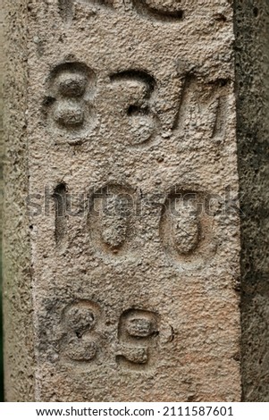 Service numbers and codes on a concrete electric pole