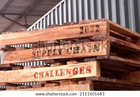 2022 Supply Chain Challenges, text written on piled-up pallets, supply chain management concept Royalty-Free Stock Photo #2111601683
