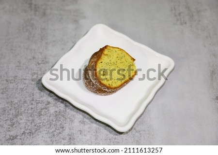 A slice of poppy seed Bundt cake on a white plate.