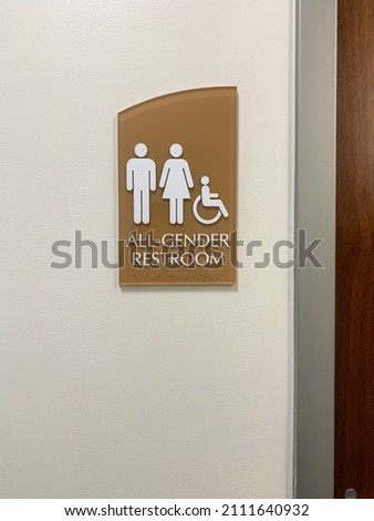 An all gender restroom sign on public restroom.