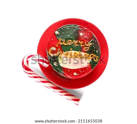 Plate with Christmas bento cake and candy cane on white background