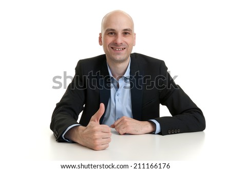 young business man at the table showing thumbs up sign. Isolated over white