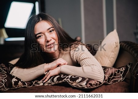 portrait of a young girl lying on a bed against the background of a Christmas tree