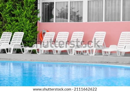 Beautiful swimming pool and sun loungers near modern hotel