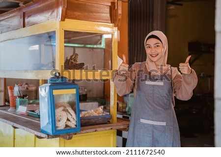 proud muslim woman with her small food stall thumb up Royalty-Free Stock Photo #2111672540