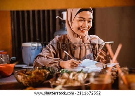 muslim woman small business seller write a note Royalty-Free Stock Photo #2111672552