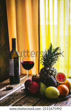 Still life of fruits and wine. The focus is on some fruits 