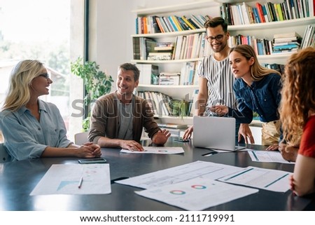 Group of happy business people working together on project in office. Royalty-Free Stock Photo #2111719991