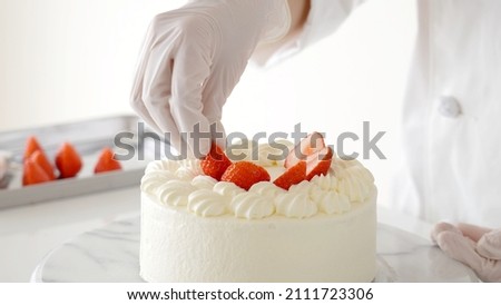 pastry chef making strawberry cake isolated on white background. Royalty-Free Stock Photo #2111723306