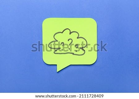 Sticky note with drawn cloud and question marks on blue background