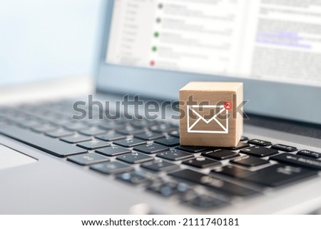 Email symbol on wooden block showing new message on laptop keyboard Royalty-Free Stock Photo #2111740181